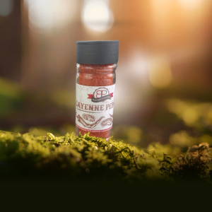 Clear glass spice jar filled with coarse, reddish-brown chilli flakes, set against a dark background.